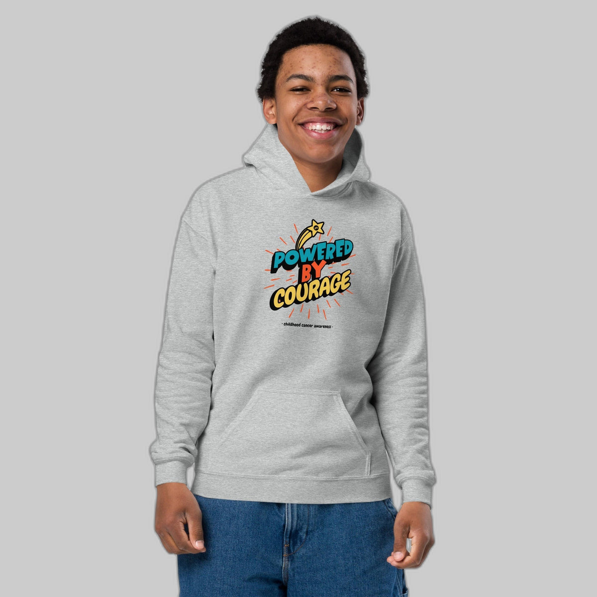 Powered by Courage youth pullover hoodie in Sport Grey, front view, gold shooting-star graphic. Childhood cancer gold ribbon kids apparel from CancerCulture®