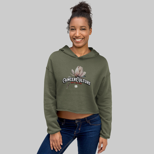 CancerCulture® Bloom Women's Crop Hoodie, Military Green, front, CancerCulture magnolia, Unite the Fight print, worn by woman, studio gray background