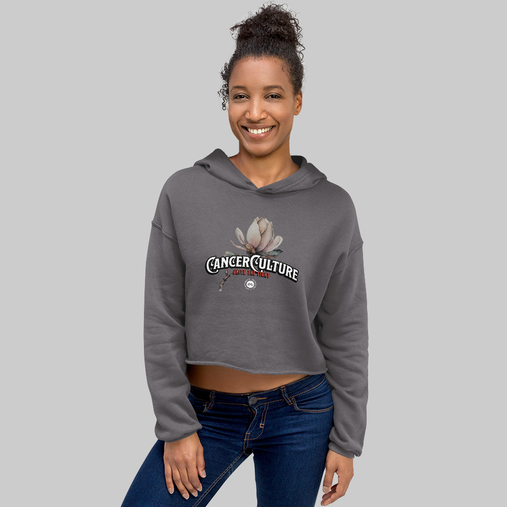 CancerCulture® Bloom Women's Crop Hoodie, Storm, front, CancerCulture magnolia, Unite the Fight print, worn by woman, studio gray background